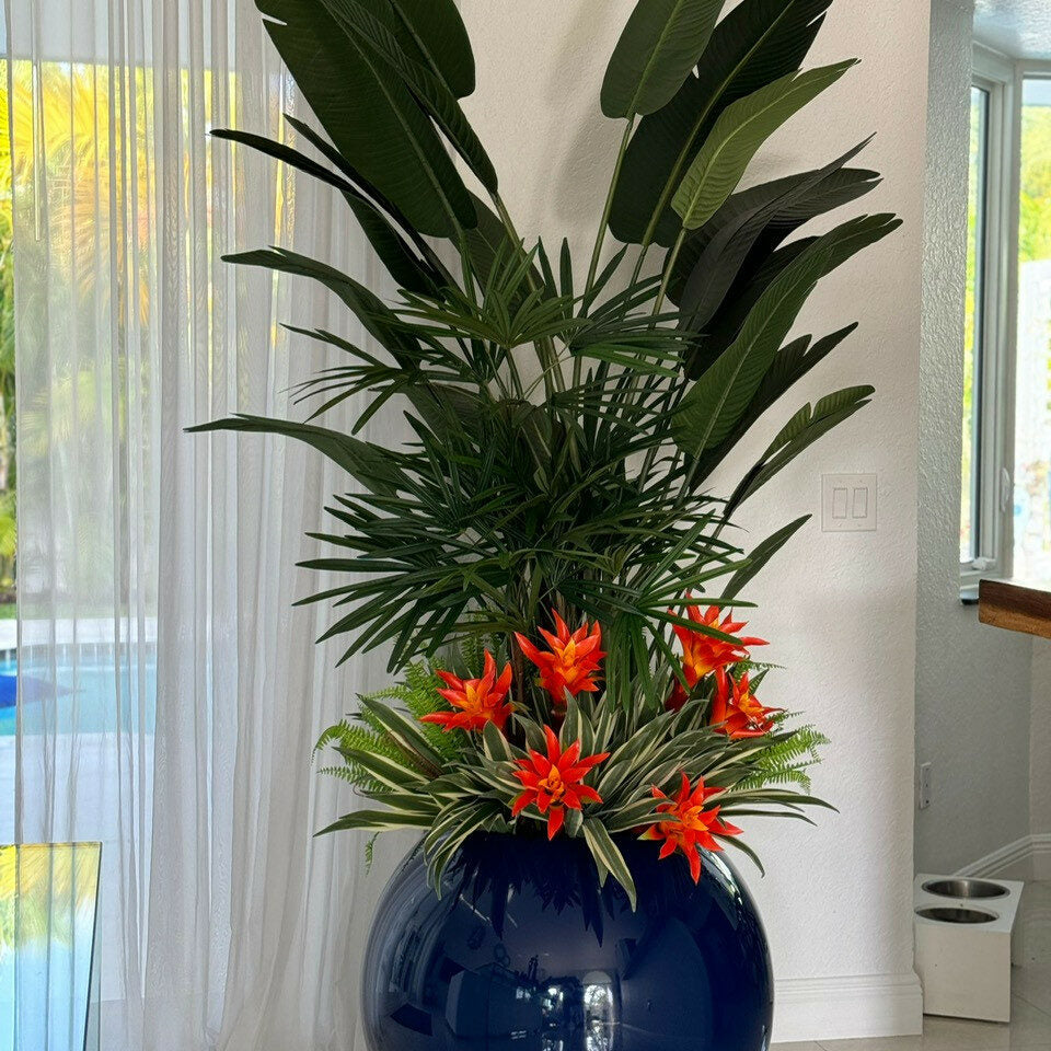 Arreglo de plantas tropicales en maceta esférica azul cobalto