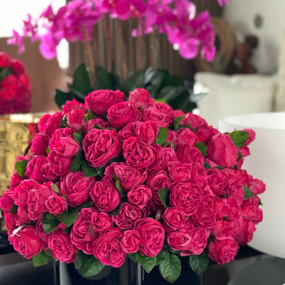 Rosas inglesas rosa intenso en jarrón de vidrio negro