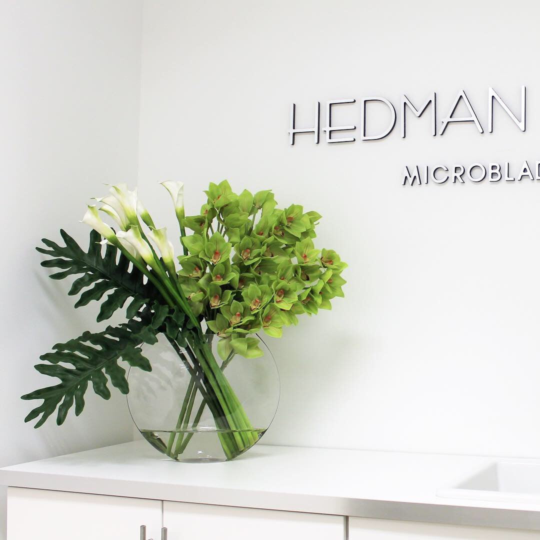 Jarrón Lunar con orquídeas Cymbidium verdes y alcatraces blancos