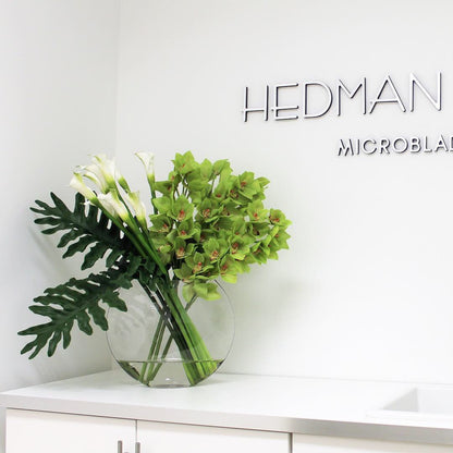 Jarrón Lunar con orquídeas Cymbidium verdes y alcatraces blancos